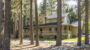 A two-story house with a stone foundation, a front porch, and a driveway.