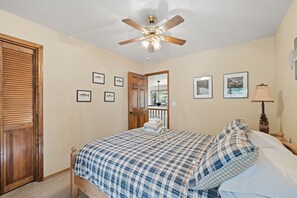 A bedroom with a bed, a ceiling fan, and framed pictures on the wall. - Fun Family Cabin in the Heart of the Lost Sierra w/ BBQ, Games and Tons of Space (Graeagle)