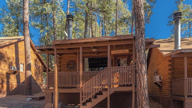 A rustic log cabin with a porch, a staircase, and a chimney. - Forest Cabin 4 Cowboys Dream (Payson)