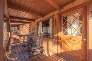 A wooden cabin with a porch, rocking chairs, and a door marked with the number 4.