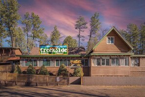 A log cabin-style building with a sign for Creekside Cabins & Tavern. - Forest Cabin 4 Cowboys Dream (Payson)