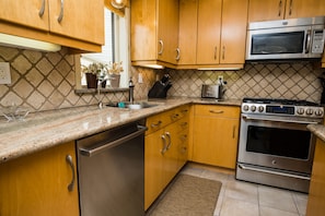 Kitchen features an oven, microwave, and stainless steel dishwasher.