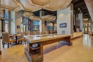 Um hall amplo com um balcão de recepção extenso, assentos confortáveis e grandes janelas que permitem entrada de luz natural.