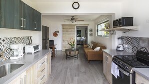 Une cuisine moderne avec un coin repas, des meubles en bois, une machine à café et une cuisinière.