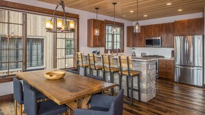 Un'ampia cucina con mobili in legno, un'isola centrale e una zona pranzo con tavolo e sedie di legno.