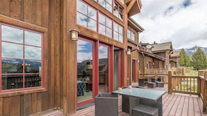Un edificio in legno con ampie finestre e una terrazza arredata con mobili da esterno.