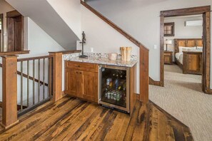 A wooden staircase with a built-in refrigerator and a small countertop.