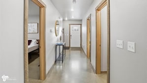 A hallway with wooden doors, a mirror, and a bed in the background. - Upper Mesa Villa #9, Glacier Suites - Upper Mesa Villa #11 (Palmer)