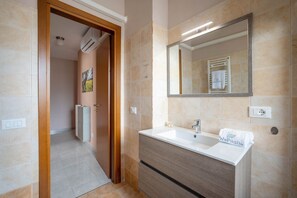 A bathroom with a sink, mirror, and towel rack.