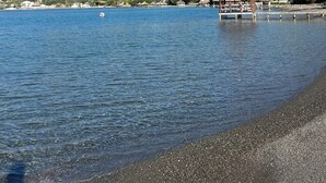 A beach with a small wooden structure, calm water, and hills in the background. - Welcome to Villa Rosa Bella. Viva la vida Bella (Palmar de Ocoa)