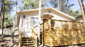 A cabin with a wooden deck, a staircase, and a window. - Remodeled cabin. New Central Air… (Ruidoso)
