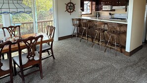 Una cocina acogedora con vigas de madera, un comedor con mesa y sillas, y vistas al exterior.