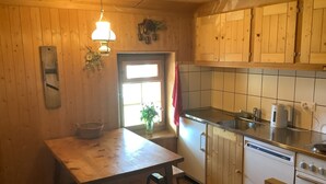 A kitchen with wooden cabinets, a sink, a stove, and a refrigerator.