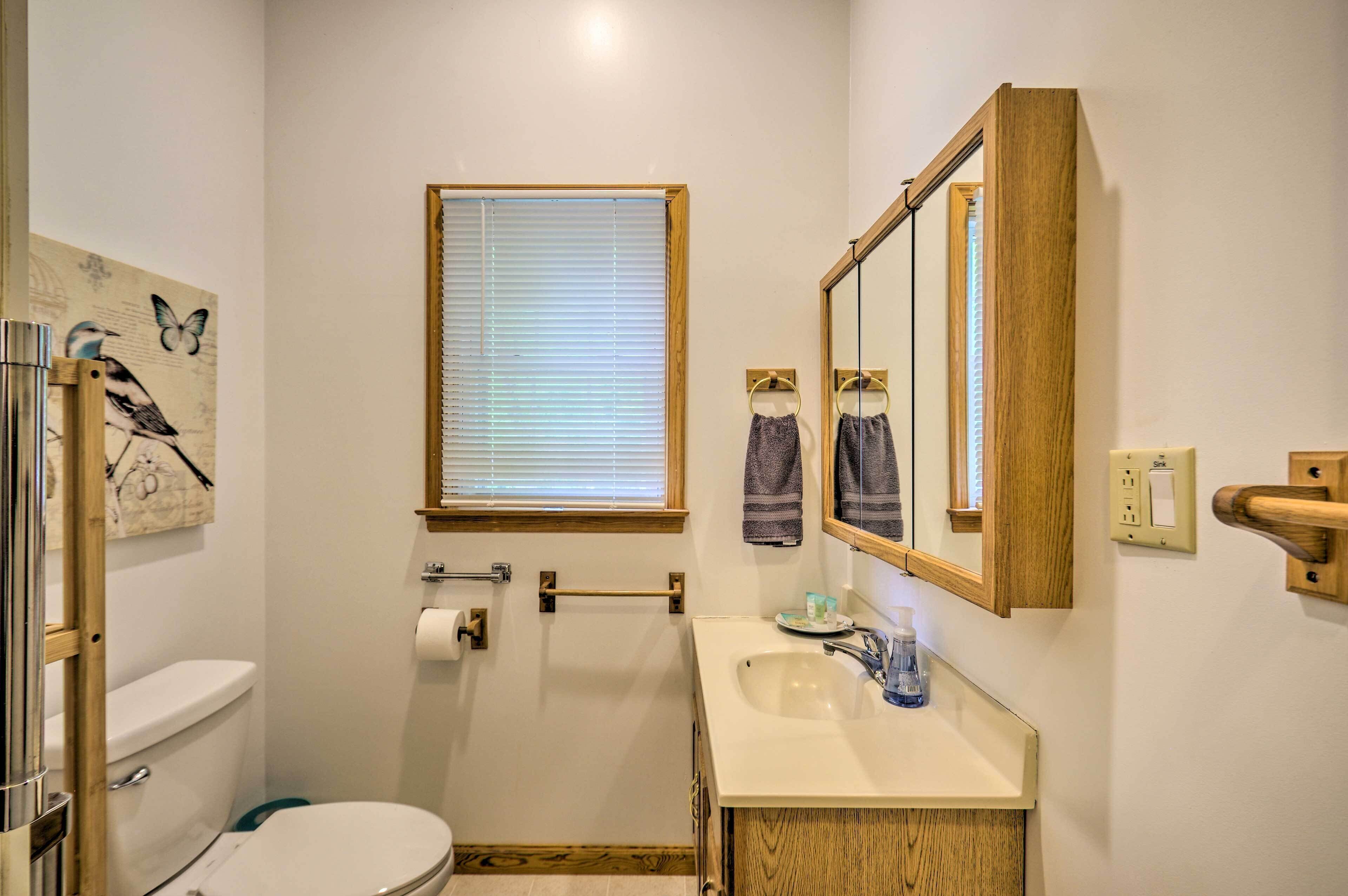 A compact bathroom with a toilet, sink, and window.
