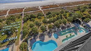 Un resort con una piscina grande, acceso a la playa y vista al océano.