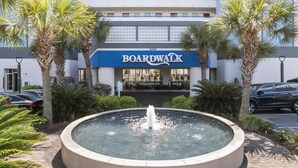 Un edificio con un cartel que dice 'BOARDWALK' y una fuente al frente.