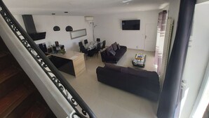 Una sala moderna con un sofá, una mesa de comedor y un televisor.