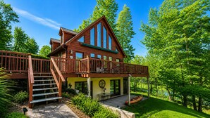 A two-story wooden house with a balcony, a covered patio, and a view of a lake. - Updated Lakefront Retreat, Fiber WiFi, Fire Pit, 15 Min to VIR (Leasburg)
