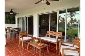 Relax in this serene outdoor space with a patio setup featuring a table, benches, and a ceiling fan.