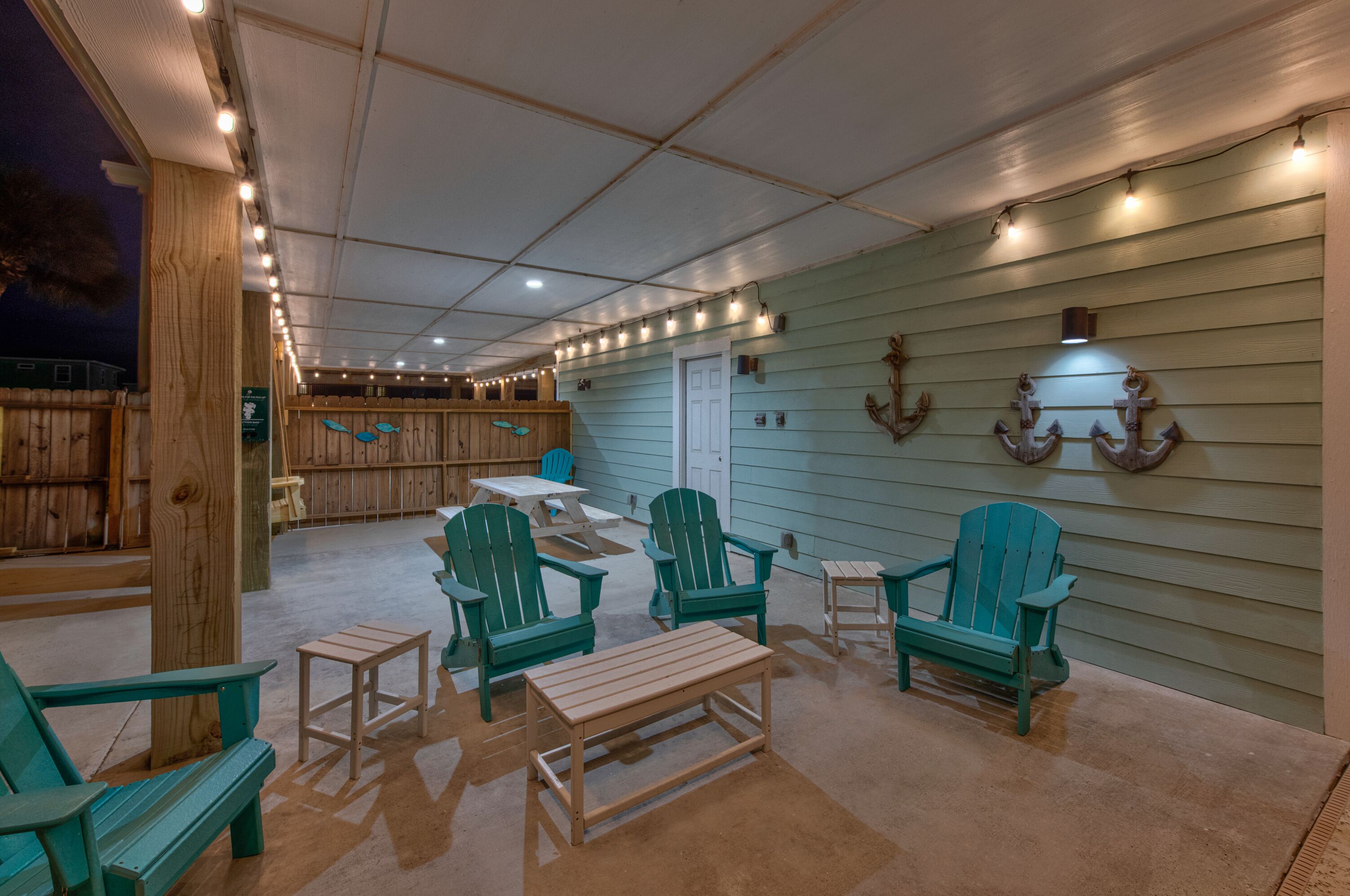 An outdoor patio area with wooden furniture and string lights.