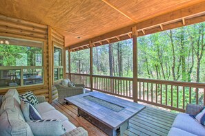A wooden deck with a sofa and a table, overlooking a forest. - Wooded Hideaway! Spacious Show Low Log Cabin (Show Low)