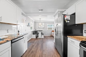 Enjoy cooking in this well-equipped kitchen with a refrigerator, sink, and ample counter space.