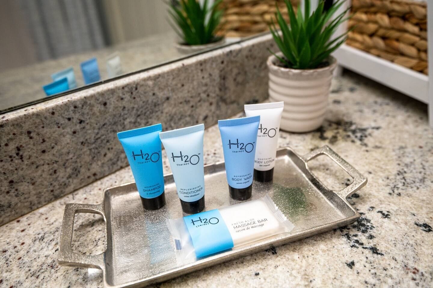 A tray with four H2O Therapy products on a granite countertop.