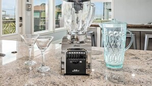 Eine Küche mit Mixer, zwei Martini-Gläsern und einer Kanne auf einer Arbeitsplatte aus Granit.