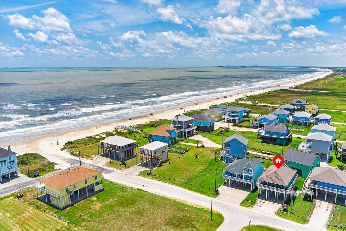 Une zone résidentielle côtière comprenant des maisons, une plage et une route.