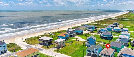 Une zone résidentielle côtière comprenant des maisons, une plage et une route.