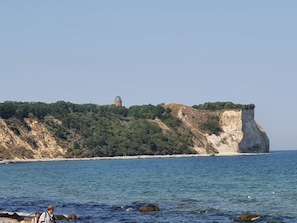 Eine Küstenlandschaft mit einer markanten Klippe und einem Gebäude mit einer Kuppel.