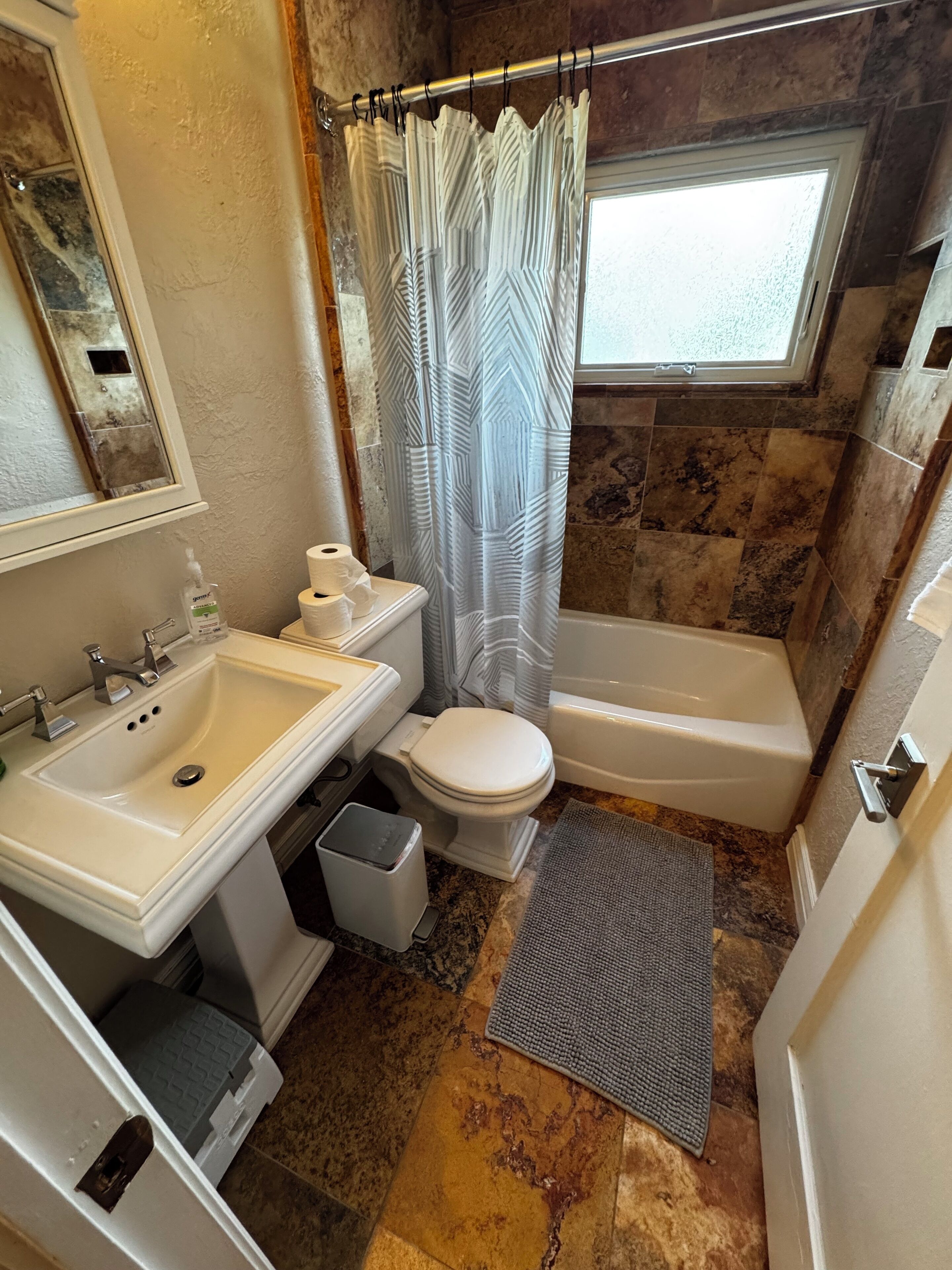 Un baño con lavamanos, inodoro y bañera.