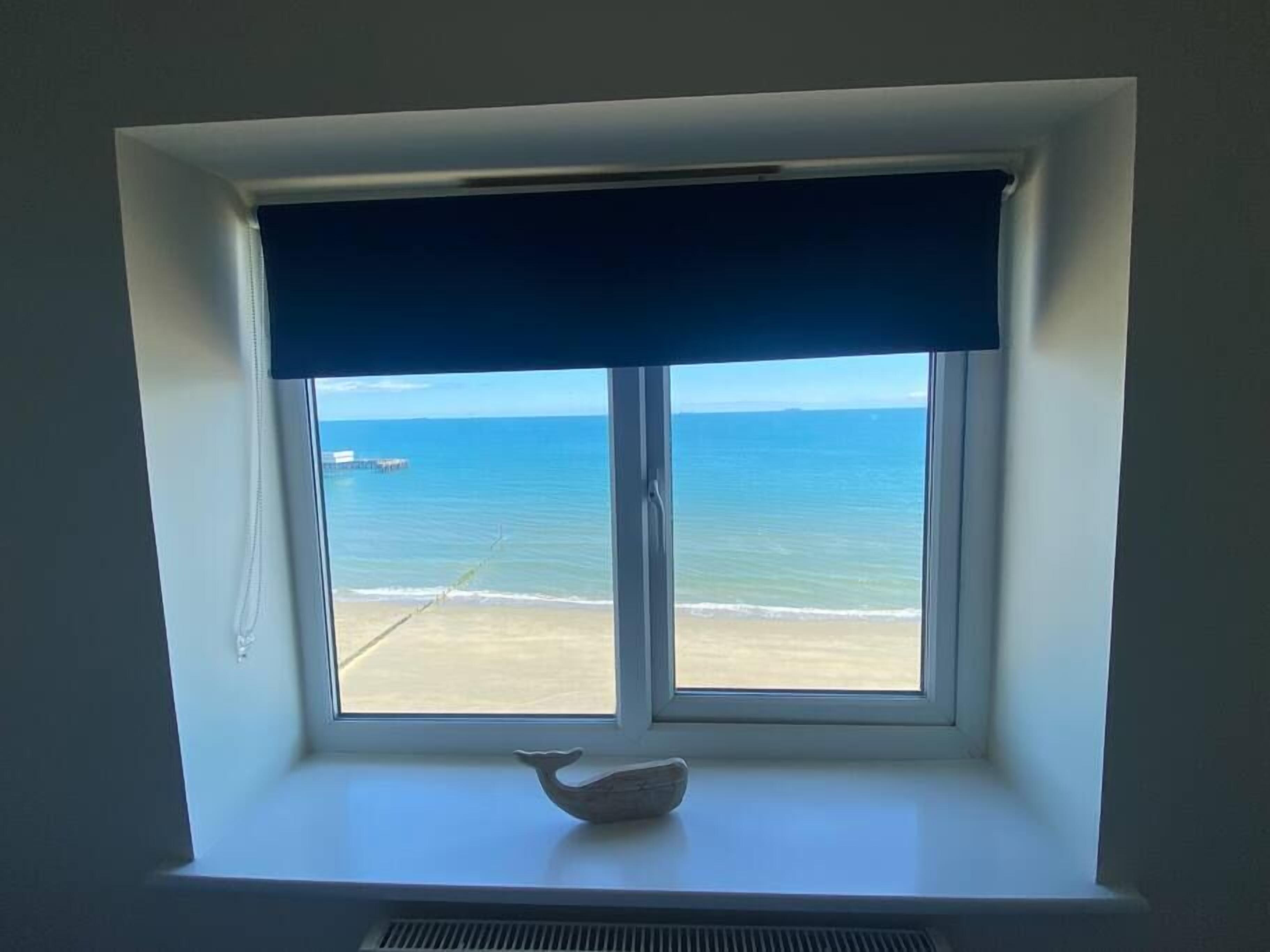 Une fenêtre donnant sur la plage et l’océan.
