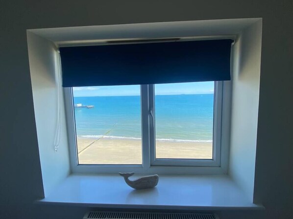 A window with a view of the beach and ocean.