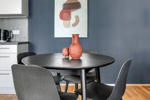 Uma cozinha moderna com uma mesa de jantar redonda, duas cadeiras e um vaso na mesa.