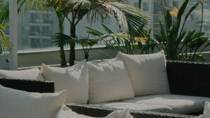 A balcony with a sofa, cushions, and potted plants. - 1BR w/ Balcony, Ideal view over Vienna, nr U2 Donaumarina, by Blueground (Vienna)