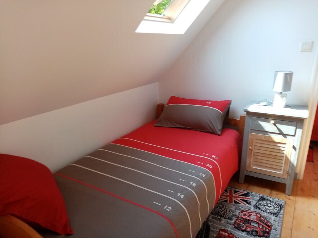 Een kleine, knusse kamer met een bed, een bureau en een raam.