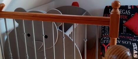 A wooden staircase with a white railing leading to a loft area.