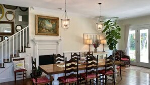 Un comedor con una mesa de madera, sillas y lámparas colgantes.