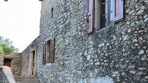 Un bâtiment en pierre avec un escalier menant à une porte.