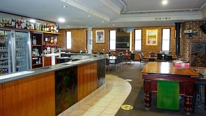 Un espace bar avec un comptoir, des sièges et un mur en briques.