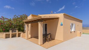 Un petit bâtiment d’un seul étage, doté d’un patio couvert, d’une porte et d’une fenêtre.