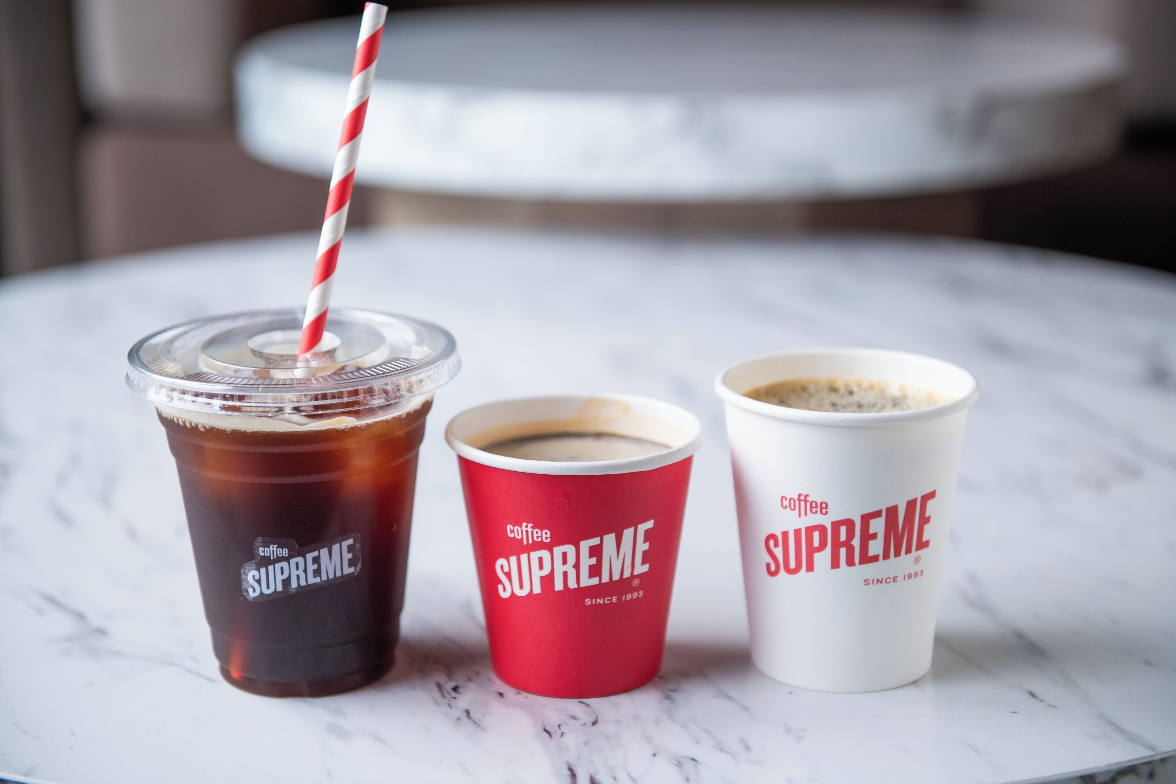 Three cups of coffee on a marble table.