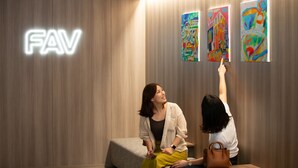 Un interior moderno con un cartel 'FAV', un sofá y obras de arte coloridas en la pared.