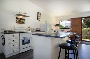 Enjoy cooking in this well-equipped kitchen with a central island, stove, and ample seating.