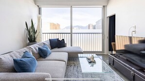 A modern living room with a sofa, a coffee table, and a TV.
