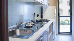 A modern kitchen with stainless steel appliances, a gas stove, and a sink. - Italian Beach Resort Apartment (Via Carlo Enrico Bernasconi, Scanzano Jonico MT)