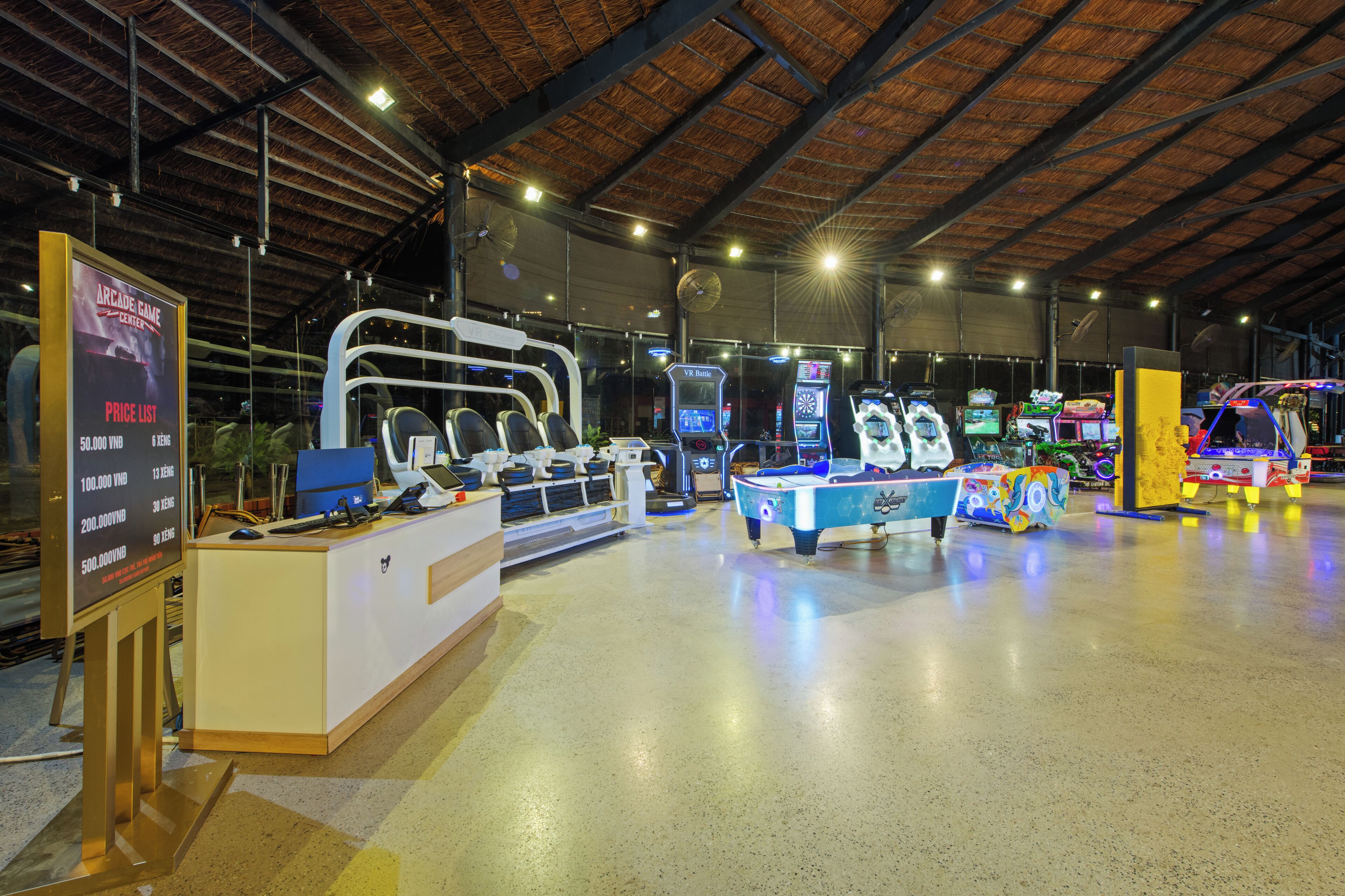 An indoor arcade with VR gaming stations, a pool table, and a reception desk.