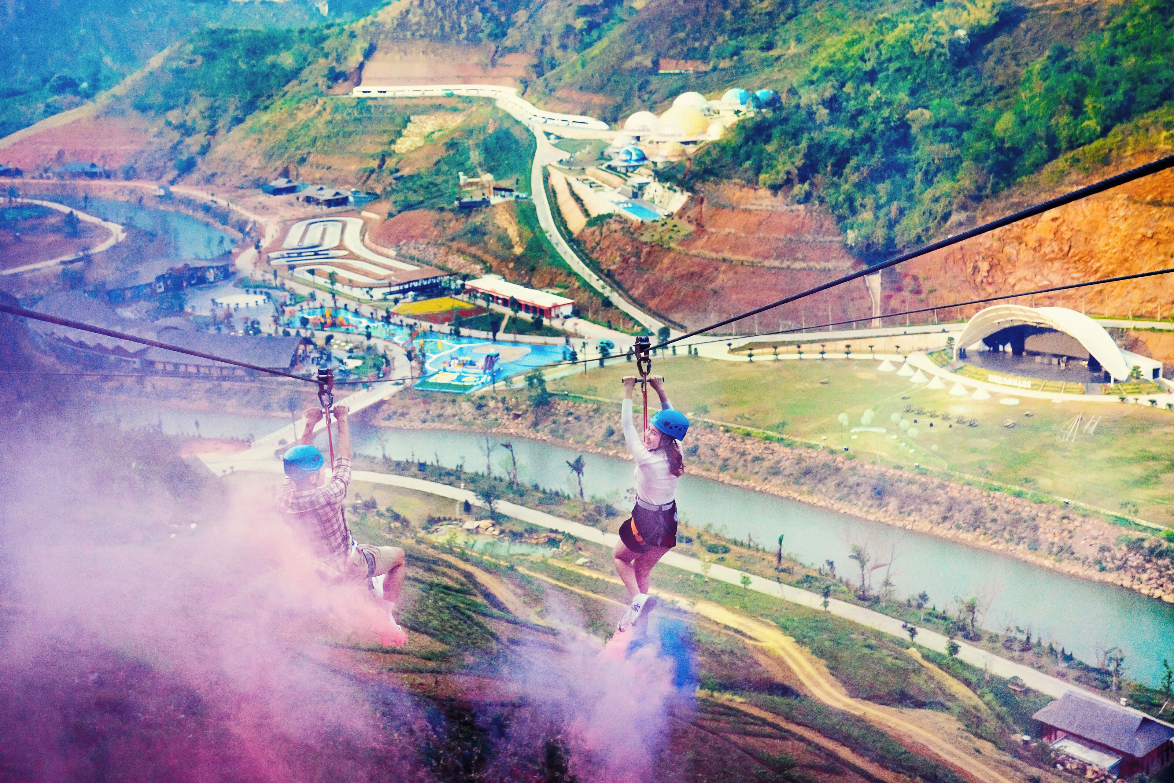 A high-altitude zip line with a scenic view of a river and surrounding landscape.