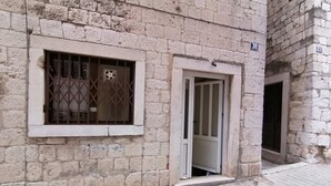 A stone building with a barred window and a door. - Apt Sleeps 2 with Sea Proximity (Split)